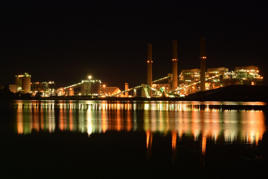 Night time shot of a natural gas refinery off the water.