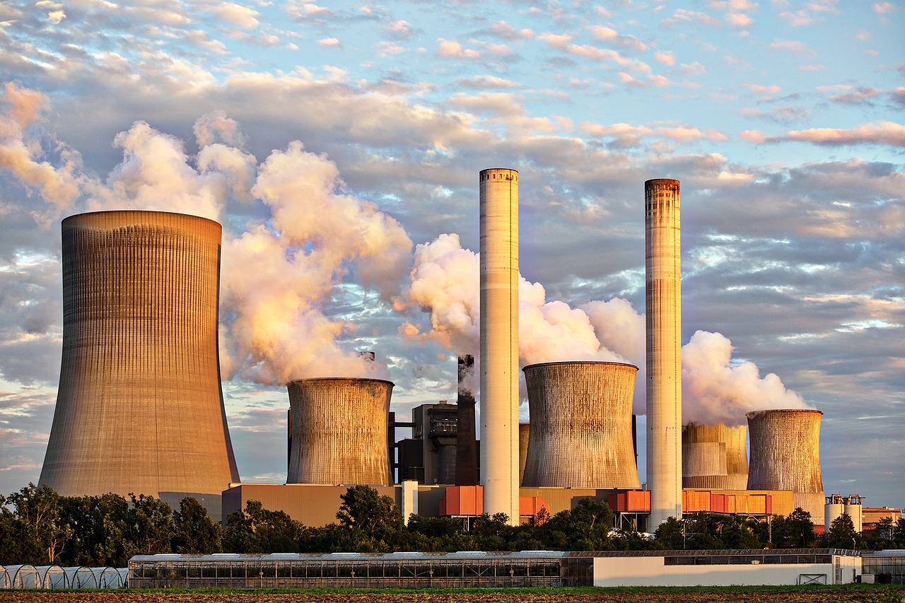 Smoke billows from the stacks of cooling towers at a coal power plant.